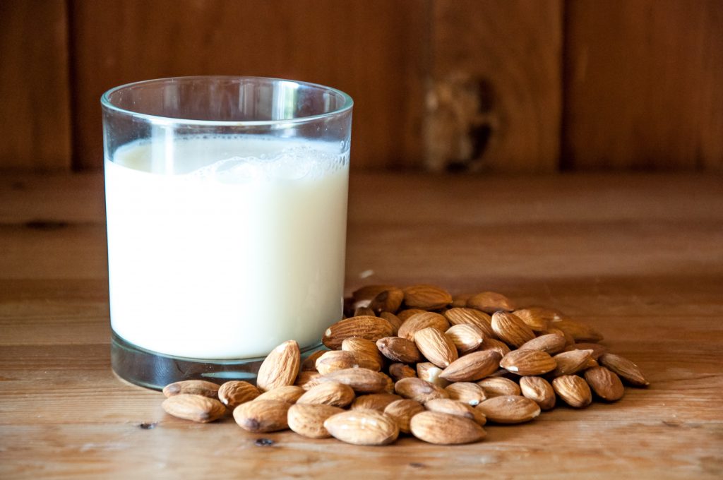 Almond milk with almond on a wooden table